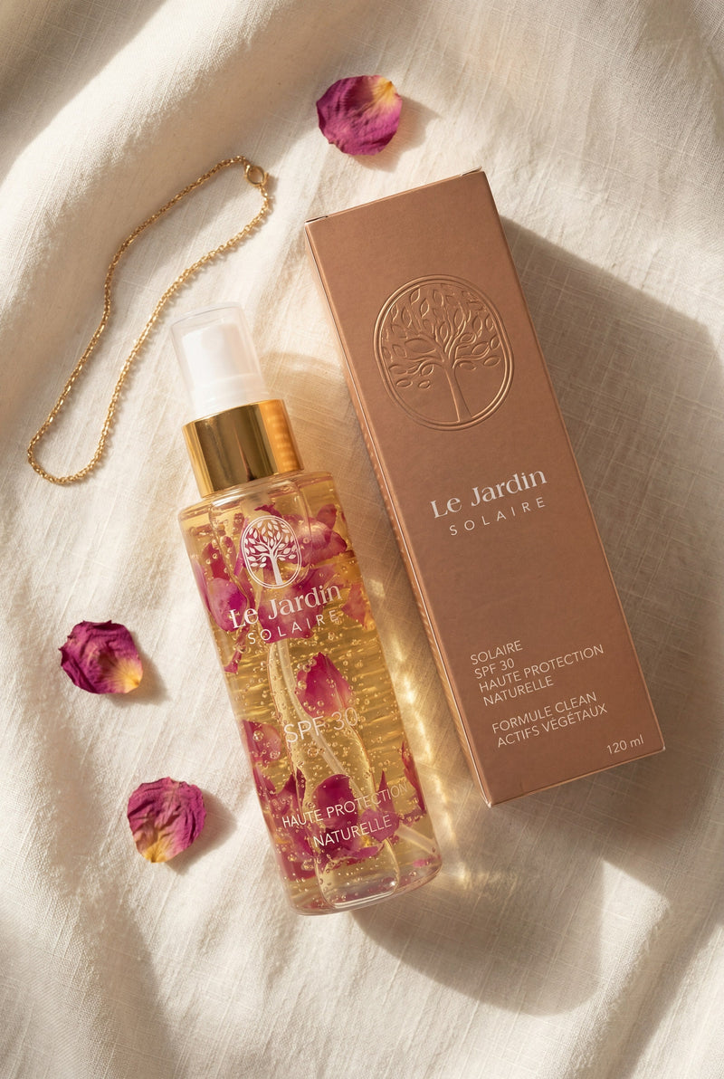 Le Jardin Solaire, Spray SPF 30, flacon aux pétales de rose de Damas et son étui, sur lin ivoire.